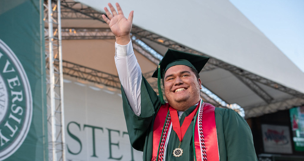 Graduate waving on stage